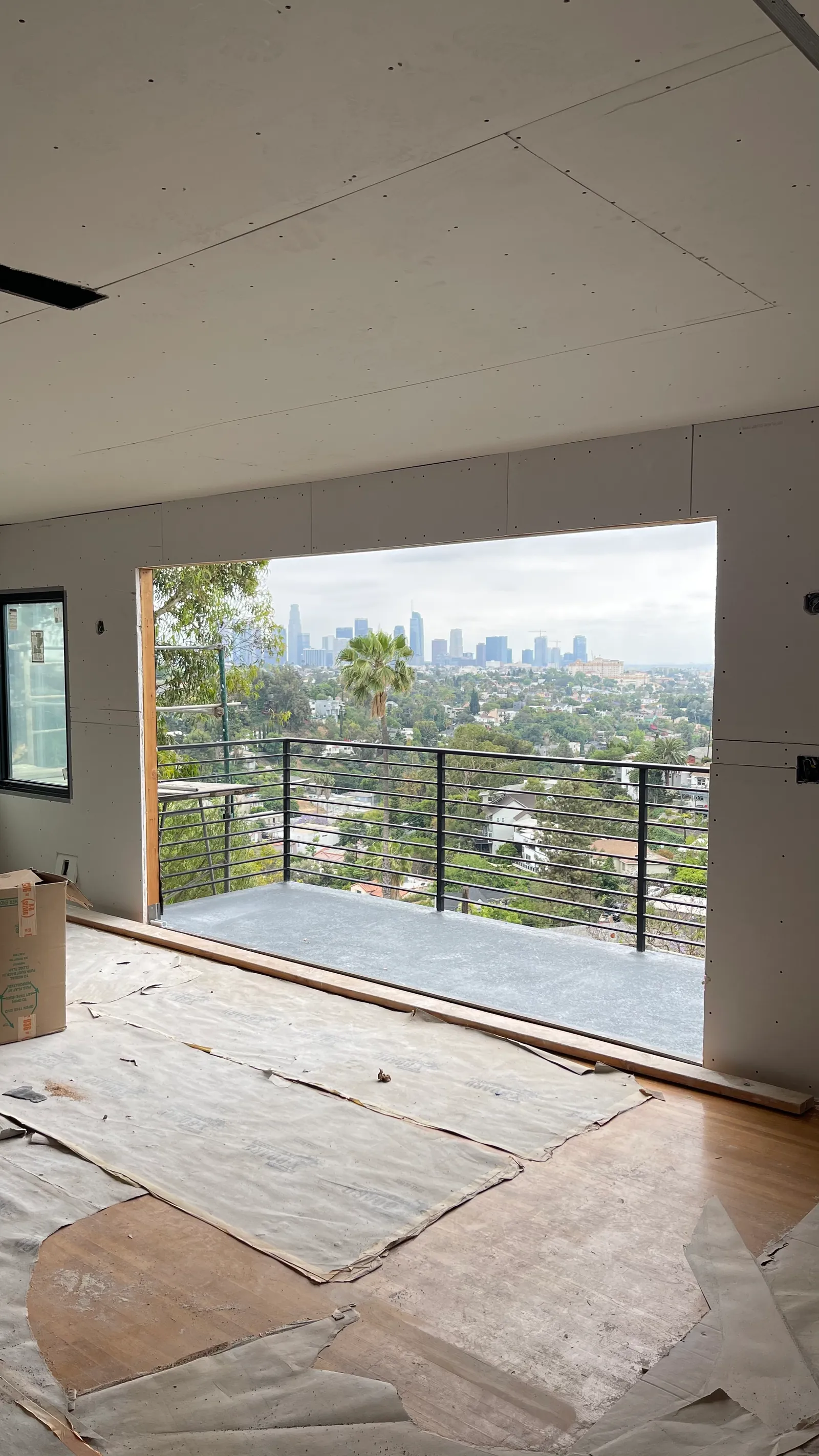 Living space hung with board, city skyline through the opening